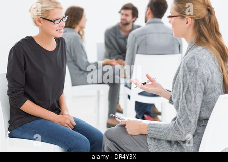 Group therapy session with therapist and client in foreground Stock Photo