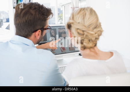 Rear view of photo editors working on computer Stock Photo