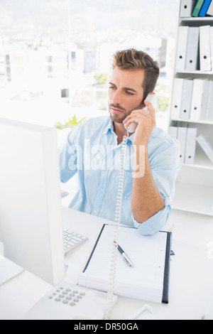 Concentrated male photo editor using phone Stock Photo