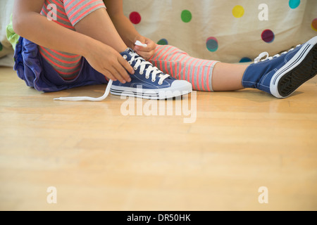 Korean girl tying shoelaces Stock Photo