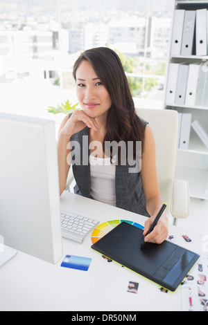 Smiling casual female photo editor using graphics tablet Stock Photo