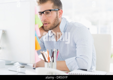 Concentrated young man using computer Stock Photo