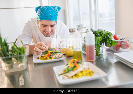 Mixed race chef plating food in restaurant Stock Photo - Alamy