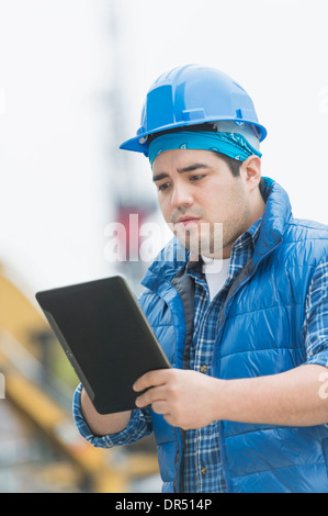 Mixed race engineer using digital tablet at construction site Stock Photo