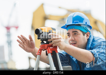 Mixed race engineer using theodolite at construction site Stock Photo