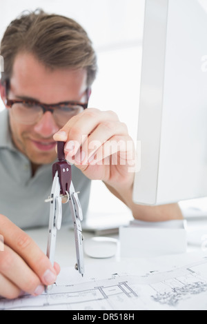 Concentrated man using compass on design Stock Photo