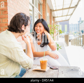 Couple enjoying iced coffee at sidewalk cafe Stock Photo