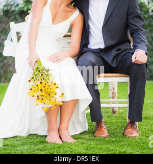 Newlywed couple sitting outdoors Stock Photo