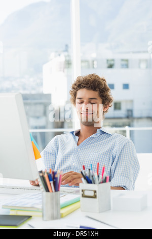 Casual young man using computer in bright office Stock Photo