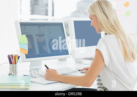 Casual young woman using computer in office Stock Photo