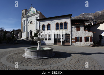 The fountain in front of the church and the old dairy ('Caseificio'). Poffabro, Carnic Prealps, province of Pordenone, Friuli, northeastern Italy. Stock Photo