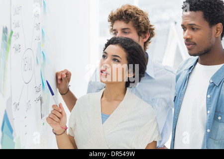 Artists in discussion in front of whiteboard Stock Photo