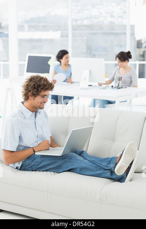 Man using laptop with colleagues at creative office Stock Photo