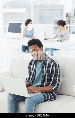 Man using laptop with colleagues at creative office Stock Photo