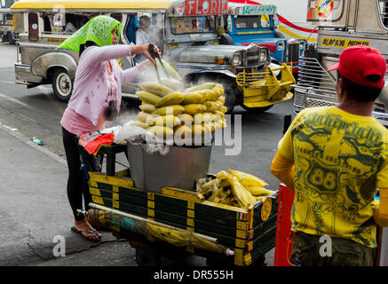 Pasay City, Philippines-January 20, 2014: Street vendor selling her sweet corn in the street of Manila. Stock Photo