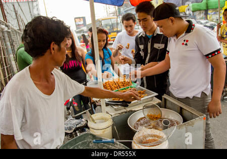 Pasay City, Philippines-January 20, 2014: Street vendor selling his fried chicken intestine. Stock Photo