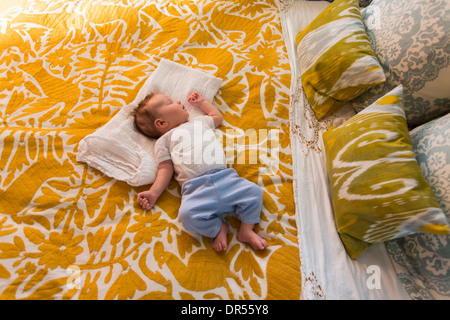 Caucasian baby laying on bed Stock Photo