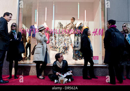 Apr 23, 2009 - New York, New York, USA - REBECCA HERBST, center, of New York, looks up from her fashion magazine while waiting in line outside of the Fifth Avenue Hennes & Mauritz store in Manhattan, awaiting the launch of British designer Matthew Williamson's line of women's clothes designed exclusively for H&M, on Thursday, April 23, 2009. Only three H&M stores in New York will c Stock Photo