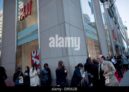 Apr 23, 2009 - New York, New York, USA - A New York businessman passes by a line surrounding the Fifth Avenue Hennes & Mauritz store in Manhattan, as a crowd waits for the launch of British designer Matthew Williamson's line of women's clothes designed exclusively for H&M, on Thursday, April 23, 2009. Only three H&M stores in New York will carry the line, and the designer plans to  Stock Photo