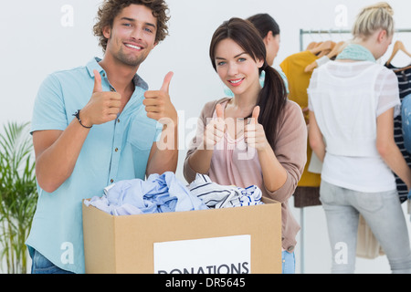 People with clothes donation gesturing thumbs up Stock Photo