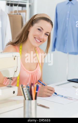 Smiling fashion designer working on her designs Stock Photo