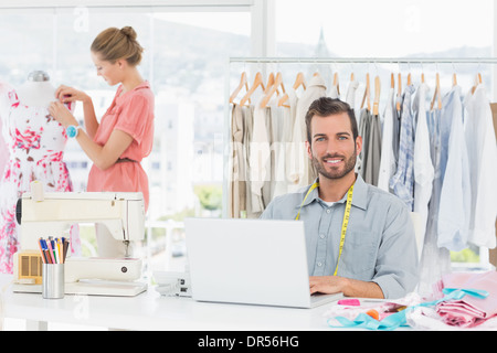 Man using laptop with fashion designer working at studio Stock Photo