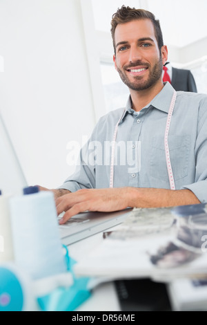 Smiling young male fashion designer using laptop Stock Photo