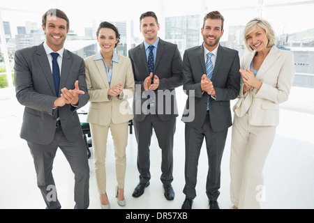 Business team clapping hands together in office Stock Photo
