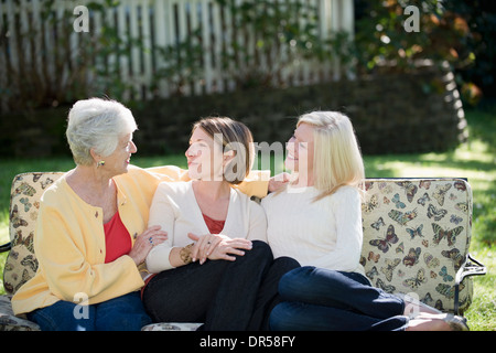 Three generations of Caucasian women relaxing outdoors Stock Photo