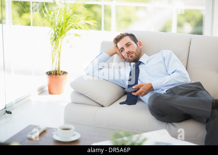 Well dressed man watching tv in the living room Stock Photo