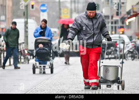 Berlin, Germany. 20th Jan, 2014. An employee of the snow and ice control grits the road in Berlin, Germany, 20 January 2014. With temperatures beneath zero degrees Celsius many streets in the city are covered with a layer of ice. Photo: Ole Spata/dpa/Alamy Live News