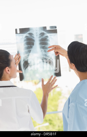 Rear view of two female doctors examining x-ray Stock Photo