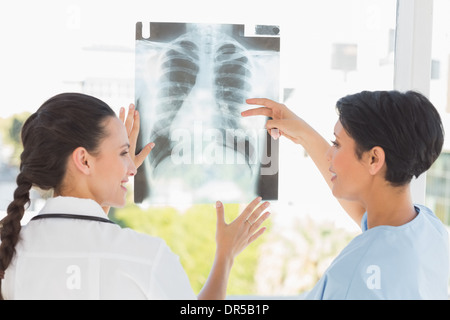 Rear view of two female doctors examining x-ray Stock Photo