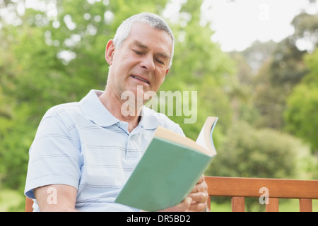 Senior man reading a book at park Stock Photo