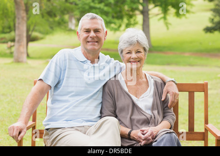Senior couple sitting on bench at park Stock Photo