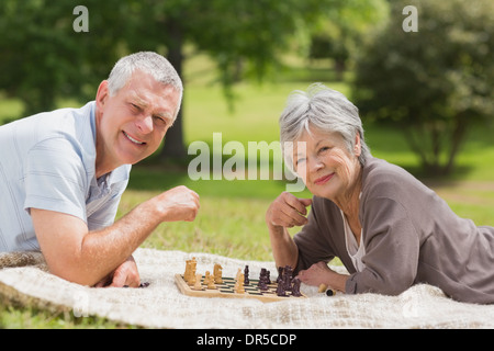 Happy senior couple playing chess at park Stock Photo