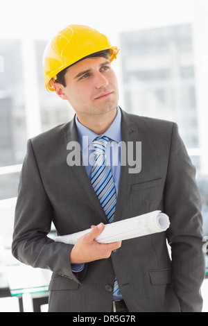 Happy architect thinking and holding blueprints Stock Photo