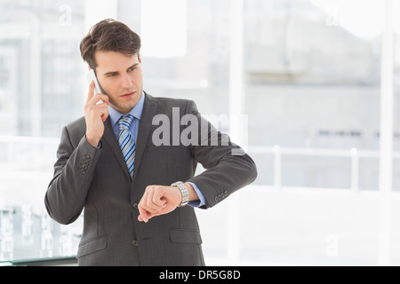 Businessman checking the time on the phone Stock Photo