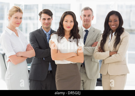 Business team smiling at camera with arms crossed Stock Photo