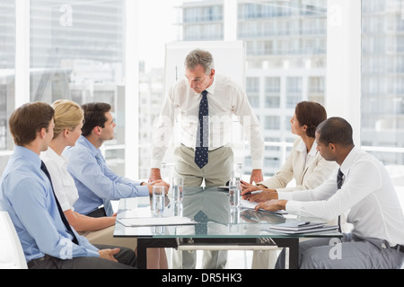 Stern businessman looking down at his staff during a meeting Stock Photo