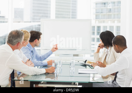 Business people looking at blank whiteboard in conference room Stock Photo