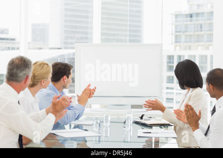 Business people applauding blank whiteboard in conference room Stock Photo