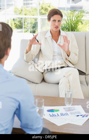 Businesswoman talking with colleague sitting on sofa Stock Photo