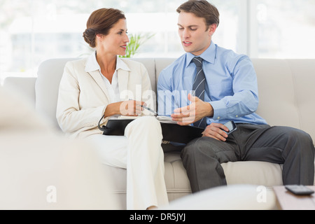 Business people planning in diary together on the sofa Stock Photo