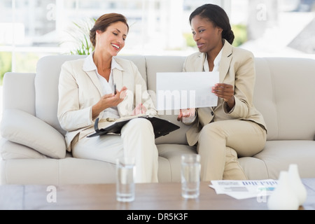 Businesswomen planning together on the sofa and laughing Stock Photo