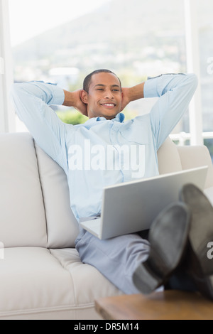Relaxed smiling businessman on the couch with laptop Stock Photo