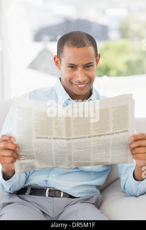 Happy businessman reading newspaper on the couch Stock Photo