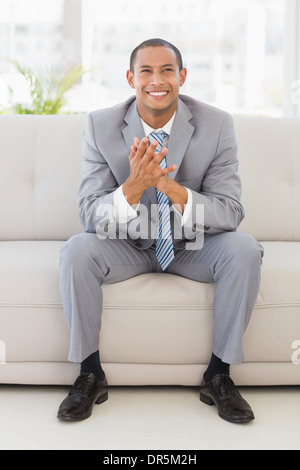 Excited businessman sitting on couch Stock Photo