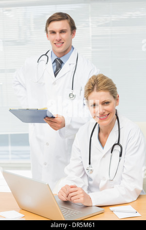Doctors smiling at the camera together Stock Photo