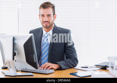 Young businessman using computer at office desk Stock Photo